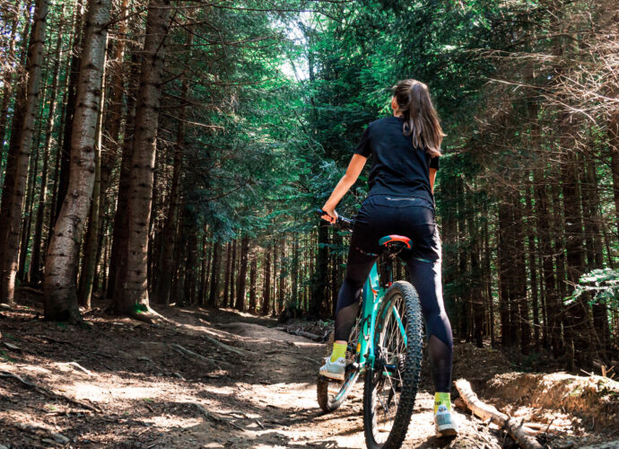 Eine Frau beim Radfahren im Wald.
